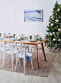 Festive table in front of decorated Christmas tree