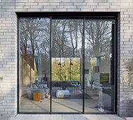 Square window looking into large living room in architect-designed house