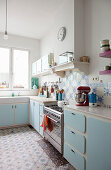 Pale-blue cabinets and patterned tiles in kitchen
