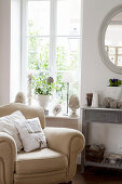 Cream armchair next to window with French-style accessories on windowsill