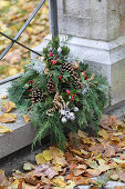 Grave arrangement of conifer twigs, Gaultheria berries, pine cones and silver ragweed