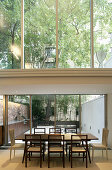 Dining table next to glass wall in narrow, architect-designed house