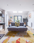 Colourful scatter cushion on grey sofa in classic living room