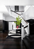 Elegant entrance hall with dark wooden floor, cassette tape and staircase