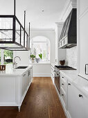 Elegante weiße Küche mit Vitrinenschrank über Kücheninsel