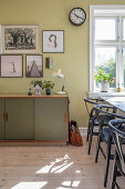 Vintage sideboard, gallery of pictures and designer chairs in dining room