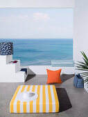 Mattress and pillows with colorful covers on terrace with sea view