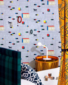 Designer wallpaper with gymnastic rings, drum as a bedside table next to bed in the children's room