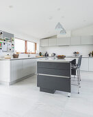 Modern grey-and-white kitchen-dining room with sloping ceiing