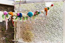 Garland of pompoms, fabric remnants and fabric flowers
