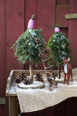 Small trees handmade from conifer branches and slices of tree trunk as wintry garden decorations