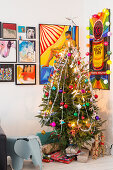 Weihnachtsbaum und Geschenke in Zimmerecke mit Comics an der Wand