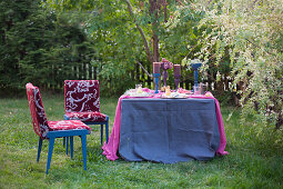 Festlich gedeckter Tisch in Blau und Violett im Garten