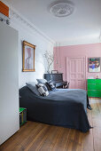 Rosafarbene Wand und Kassettentür im Altbau-Schlafzimmer