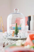 Winter landscape with animal figurines under glass cover