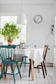 Set dining table and various chairs on white wooden floor