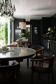 Round dining table and chairs in black kitchen
