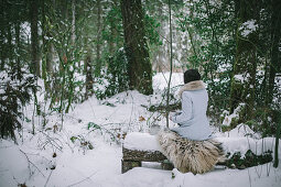 Woman drinking tea in snowy woods