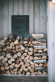 Firewood stacked against façade in winter