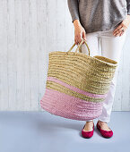 A woman holding a basket with pink stripes