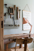 Desk made from old workbench and tools decorating wall