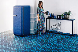 Blauer Fliesenboden mit organischem Muster und blauer Kühlschrank, Frau an Konsole