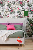 White double bed with headboard against floral wallpaper