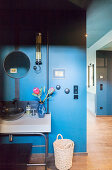 Waschtisch mit Waschbecken an blauer Wand im Flur