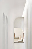White hallway with organic shapes, arches and skylight
