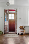 Front door with vestibule in wood-clad hallway
