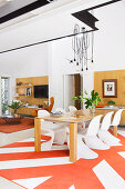 Designerstühle am Esstisch im offenen Wohnraum