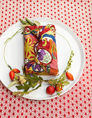 Gift wrapped in fabric with autumnal pattern on plate