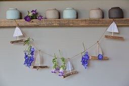 Handcrafted garland of paper boats and summer flowers