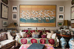 Japanisches Wandpaneel mit Vögeln über osmanischem Sofa im Wohnzimmer