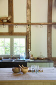 Rustic country-house kitchen in converted barn with timber frame