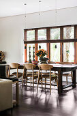Wooden chairs on the massive table in the dining room in shades of brown