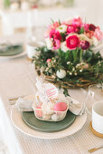 Place setting decorated with Easter basket with flower arrangement in background