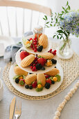 Berries and madeleines on cake stand on table festively set for afternoon coffee