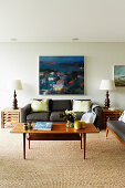 Gray sofa set, side tables with table lamp and coffee table in the living room, works of art on the wall