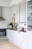 Scandinavian country-house kitchen in white and grey with wooden floor