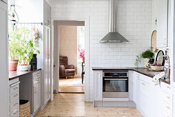 Country-house kitchen in white and grey with subway tiles and wooden floor