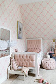 Bed, pouffe and dolls' house in girl's bedroom in pale pastel shades