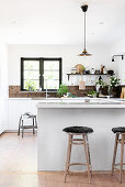 Kitchen counter used as partition in open-plan kitchen with rustic accessories