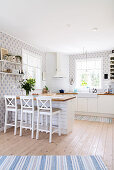 Breakfast bar, runner and wallpaper in shades of blue in bright, open-plan kitchen