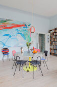 Round dining table and retro chairs in front of large painting