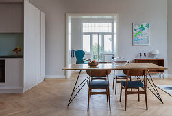 Filigraner Esstisch mit Stühlen in offenem Wohnraum, Küche als maßgefertigter Kubus