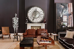 Large clock above fireplace in living room in shades of brown and black