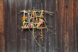Imaginative, autumnal flower arrangement on barn door