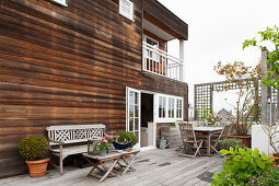 Geräumige Terrasse vor Haus mit Holzfassade