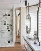 Marble shower cubicle, vintage mirrors and glass sink